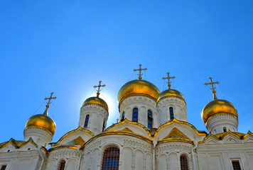 Fototapeta na wymiar Golden domes and cross of historical old Annunciation Cathedral in Moscow Kremlin, Russia