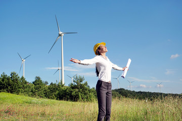 An engineer controls the functioning of wind turbines that run thanks to the force of the wind and generate electricity sustainably to the planet. Concept of: renewable energy, love for nature 