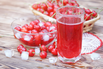 Cheery compote drink with ice on wooden table