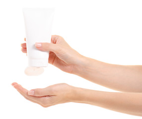 White bottle of body cream in hand on white background isolation
