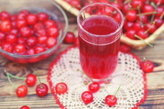 Homemade cherry compote in glass on table, selective focus