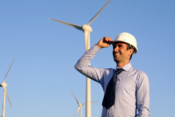 An engineer controls the functioning of wind turbines that run thanks to the force of the wind and generate electricity sustainably to the planet. Concept of: renewable energy, love for nature 