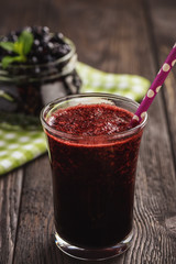 Blueberry smoothie in glass, on dark background.