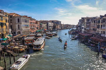 Overview of buildings, piers and gondolas in front of the Canal Grande. At the city center of Venice, the historic and amazing marine city. Veneto region, northern Italy