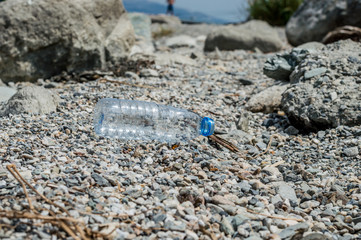 Empty plastic garbage dumped on pebble stones