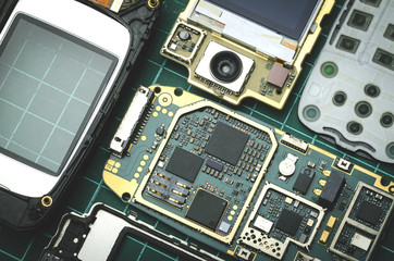 Fototapeta premium Components of old mobile phone close-up on green background