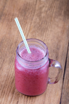 Healthy eating, food, dieting and vegetarian concept - glass of smoothies from strawberries, raspberries and banana, close up