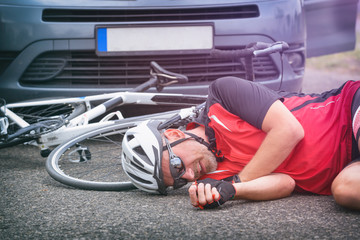 Cyclist lying on the road after hitting by a car © Monika Wisniewska