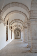Walkway moving towards perspective through cloister and arches at Igreja e Convento da Graca in Lisbon, Portugal