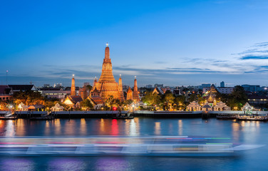 Fototapeta premium The boat was sailing in Chao Phraya River, background Wat Arun at sunset time ,Bangkok, Thailand. The Temple of Dawn