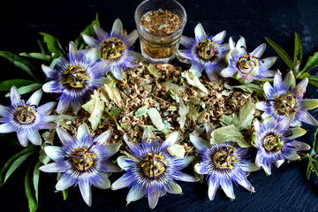 Tee von der Passionsblume mit getrockneten Blättern und Stängeln und einem kleinen glas Tee