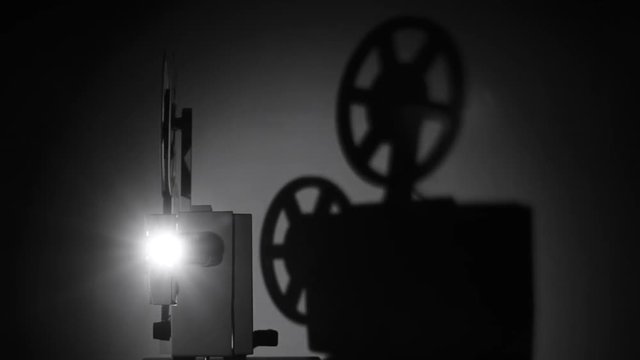 Movie projector 8-mm film. The film projector is loaded with a film and a film is shown.	