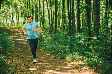 adult young man running in woods. copy space. smiling