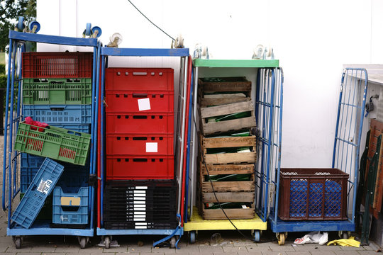 Gem&uuml;sekisten  / Gestapelte Gem&uuml;sekisten und Paletten auf Rollwagen im Hinterhof eines Obst und Gem&uuml;seh&auml;ndlers.