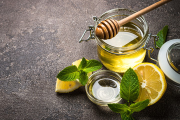 Honey in a jar with lemon and mint.