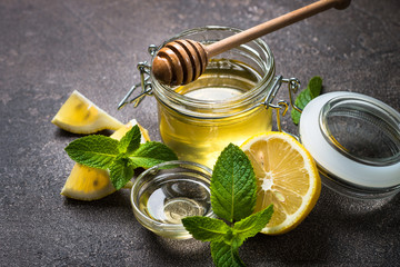 Honey in a jar with lemon and mint.