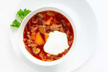 sour cream in borscht soup with green spring of lovage