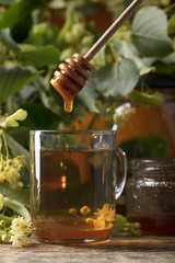 Glass of linden tea with honey  on wooden table.