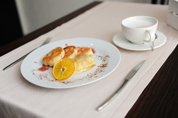 Served breakfast in the restaurant. Cottage cheese pancakes with orange ringlets and coffee