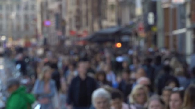 Crowd of anonymous people walking on busy street
