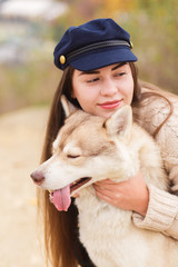 Woman hugging husky dog with stuck out tongue. Close up portrait