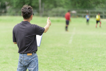 Football or socker coach observing kid football match.Healthy sport concept.