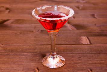 Red cocktail with decorated with sugar on a wooden table