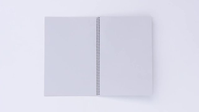 Turning page binder book by wind on a white background