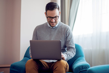 Handsome man working at home in a living room