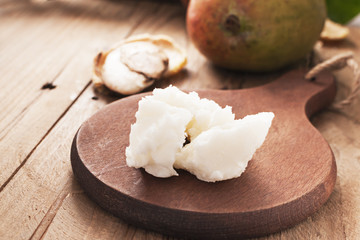 Mango butter  on dark wooden board. Organic healthy food concept. Beauty and SPA concept.