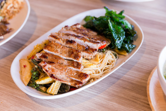 Drunken noodles: Spicy fried egg noodle with basil and pepper served with grilled pork.