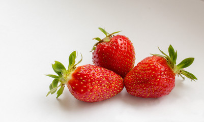 Three red strawberries at white background