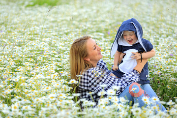 Matka z córką bawią się na łące pełnej kwiatów. - obrazy, fototapety, plakaty