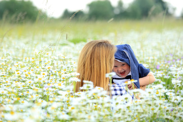 Matka z córką bawią się na łące pełnej kwiatów.