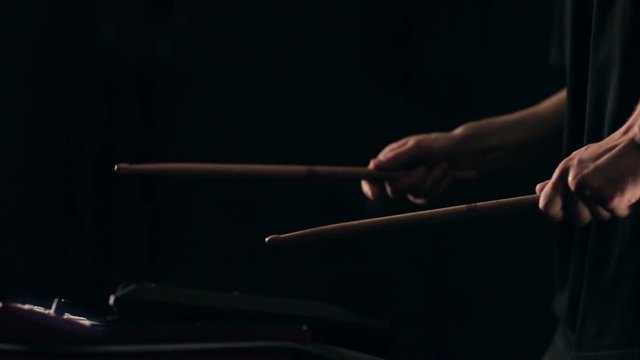 Close up slow motion shot of man drums sticks on sampler and electronic pads