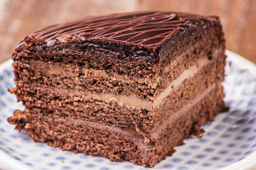 chocolate cake on a plate on wooden background.