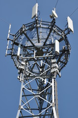 Top of the telecommunication tower with installed antenna system for wireless data transmission against blue sky