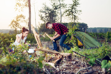 Naklejka na ściany i meble Young couple setting up tent outdoors,hiking and camping