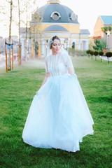 Charming young bride in white dress and veil walking to the church