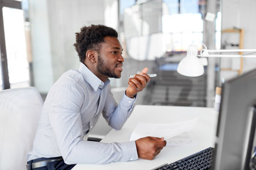 business, communication and technology concept - african american businessman with papers calling or using voice recorder on smartphone at office