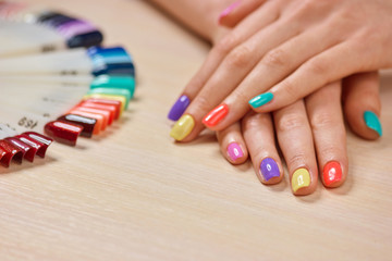 Young girl summer colored manicure. Female hands with modern summer nails on nails studio table. Glamorous summer manicure.