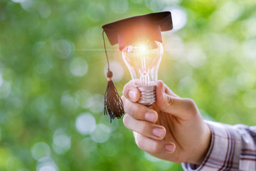 Hand shows light bulb in the cap academic .