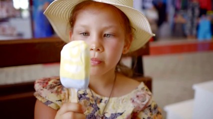 cute little girl in straw hat eating cold refreshing ice cream Popsicle