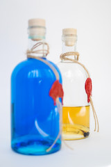 glass bottle with blue Curacao alcohol and lemon color on white background.