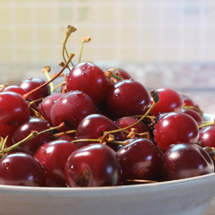 Ripe red fresh cherry in sunlight in a dish