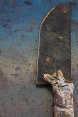 Vintage butcher cleaver on grunge rusty table, space for text or menu