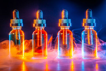 A concept with an electronic cigarette. Vape. Bottles with liquid for electronic cigarette.  A...