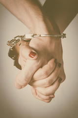 Man and woman's hands handcuffed together