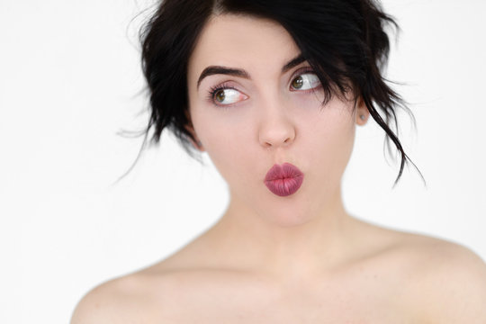 emotion face. playful coquettish kittenish skittish flippant childish woman. pin up style pout. young beautiful brunette girl portrait on white background.