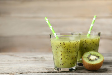 Fresh kiwi smoothie in glass on grey wooden table